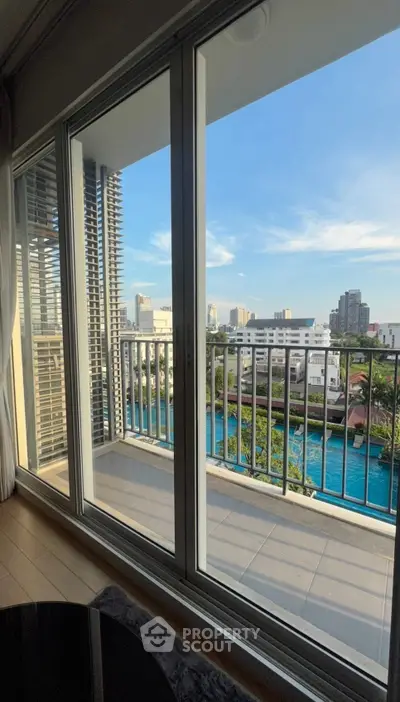 Stunning balcony view with cityscape and pool, perfect for relaxation and urban living.