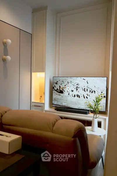 Cozy living room with modern decor and wall-mounted TV, perfect for relaxation.