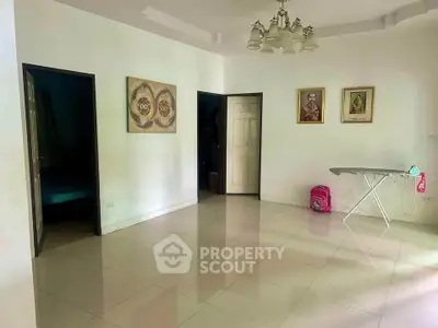 Spacious room with tiled flooring and elegant chandelier, ideal for versatile interior design.