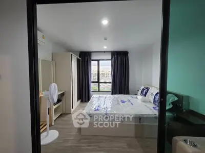 Modern bedroom with large window and stylish furnishings in a contemporary apartment.