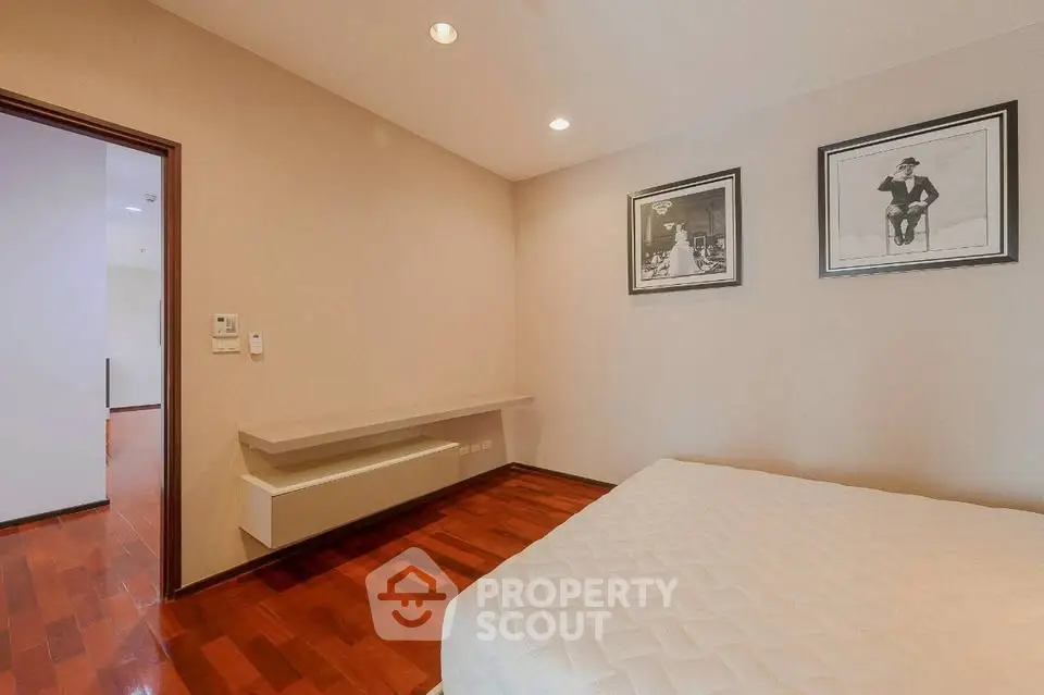 Spacious bedroom with elegant wood flooring and modern decor