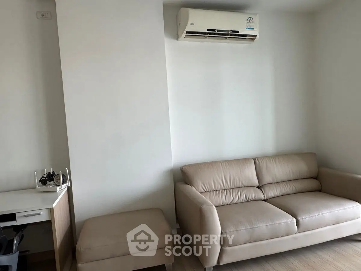 Modern living room with beige sofa and air conditioning unit, perfect for comfortable living.