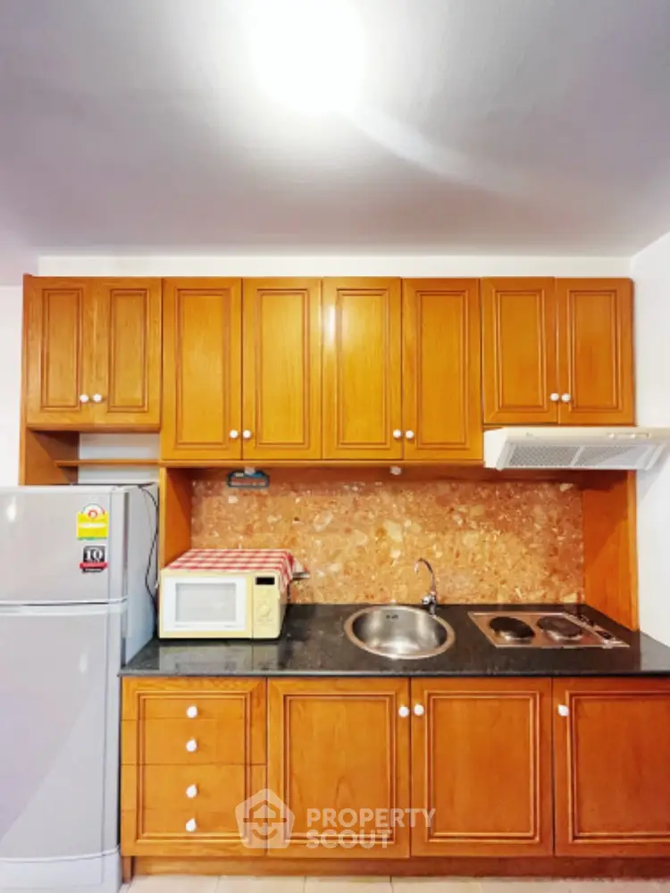 Charming kitchen with wooden cabinets and modern appliances in cozy apartment