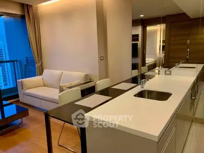 Modern open-layout living room with sleek kitchen and city view balcony.