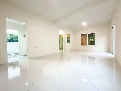Spacious modern living room with glossy marble floors and large windows.