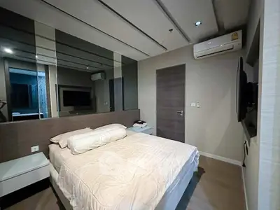 Modern bedroom with mirrored wall and sleek design in a stylish apartment.