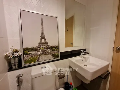 Chic bathroom with modern fixtures and stylish Eiffel Tower artwork.