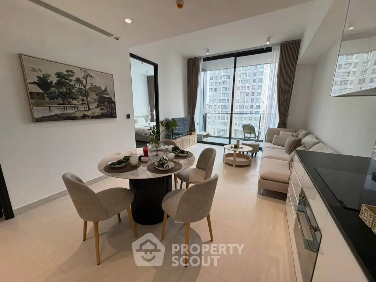 Modern open-plan living room with dining area and large windows offering city views.