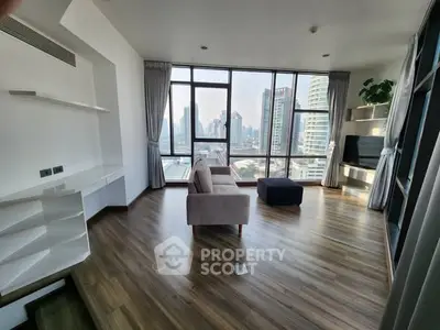 Spacious modern living room with panoramic city views and sleek wooden flooring.