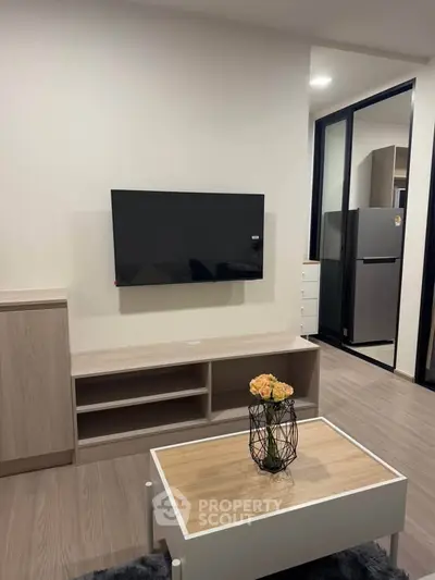 Modern living room with sleek TV setup and stylish decor in a contemporary apartment.