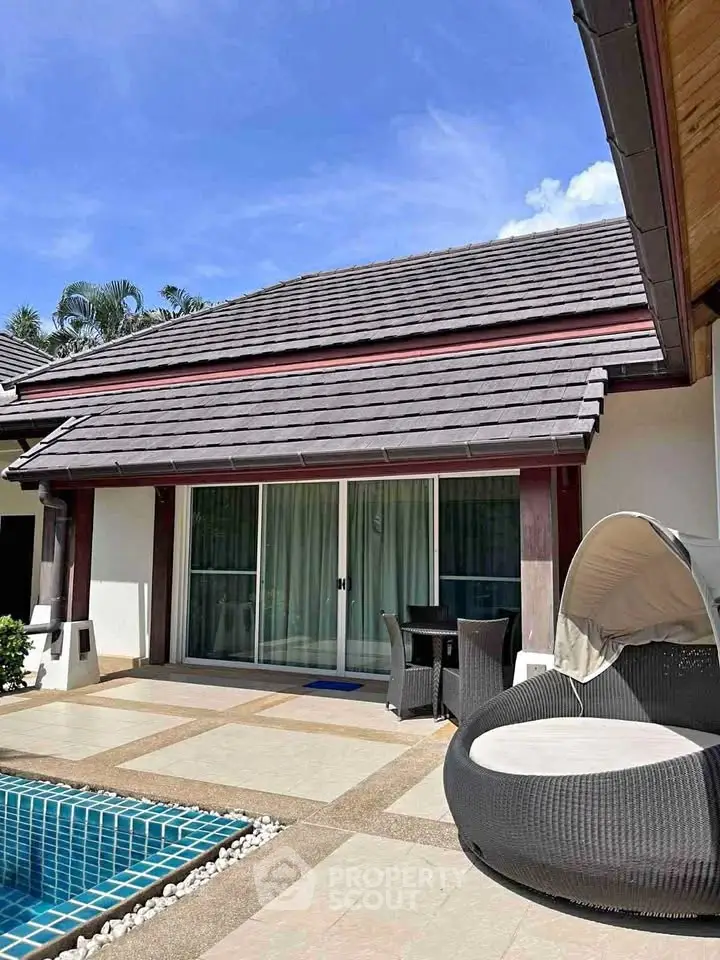 Luxurious villa with private pool and stylish outdoor seating area under a clear blue sky.