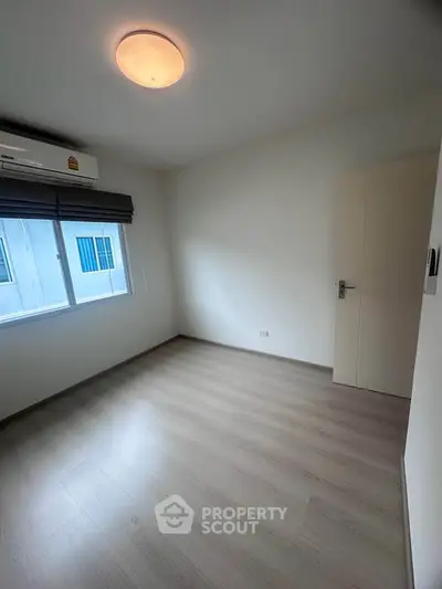 Spacious empty bedroom with natural light and modern flooring