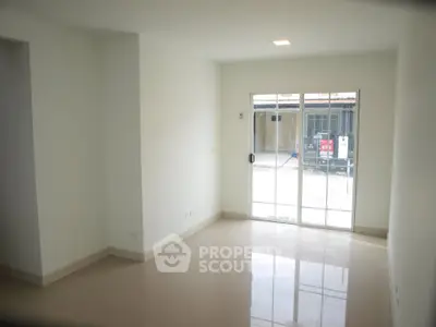 Spacious empty living room with large windows and glossy tiled floors