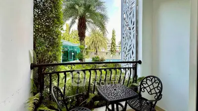 Charming balcony with elegant wrought iron furniture and lush garden view.