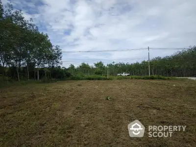 Expansive plot of land with lush greenery and clear skies, perfect for development opportunities.