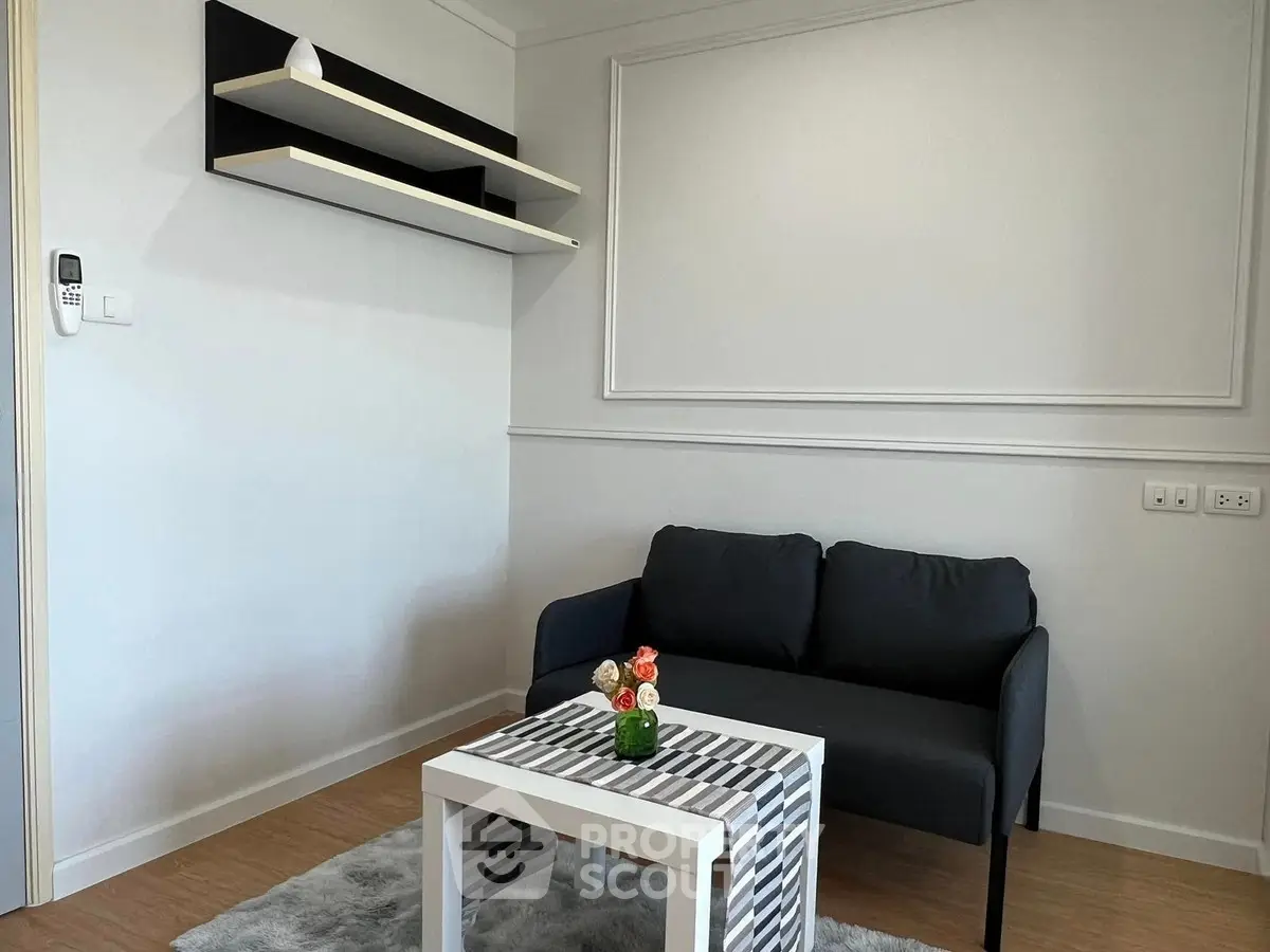 Modern living room with sleek black sofa, stylish shelves, and chic coffee table in a cozy apartment.