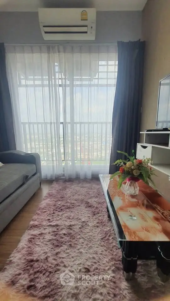 Cozy living room with large window and stylish decor, offering a bright and inviting atmosphere.