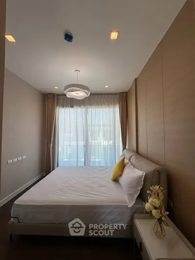 Elegant bedroom with modern decor, large window, and stylish lighting in a contemporary apartment.