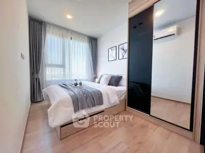Modern bedroom with large window and mirrored wardrobe, featuring stylish decor and natural light.