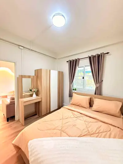 Cozy bedroom with stylish decor and natural light, featuring a comfortable bed and elegant curtains.