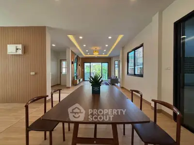 Spacious modern living room with elegant dining area and large windows offering natural light.