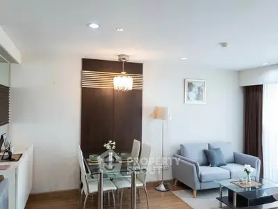 Modern living room with dining area, featuring stylish furniture and elegant lighting.