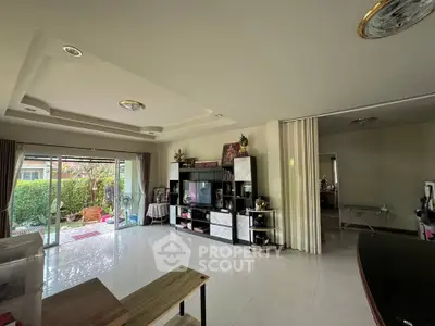 Spacious living room with modern entertainment center and garden view, perfect for family gatherings.