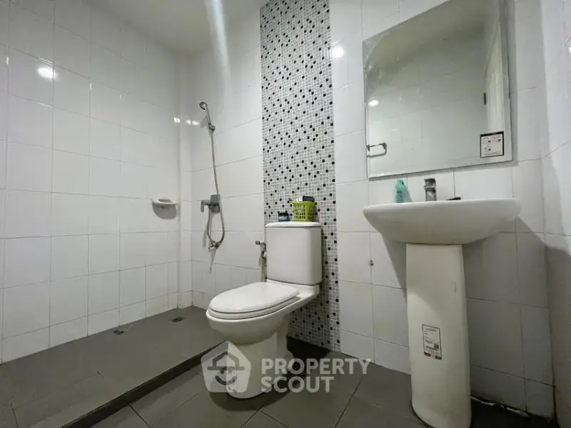 Modern bathroom with sleek fixtures and stylish tile accent wall.