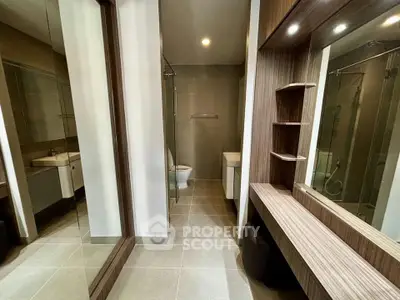 Modern bathroom with sleek design, featuring a glass shower and elegant wooden accents.