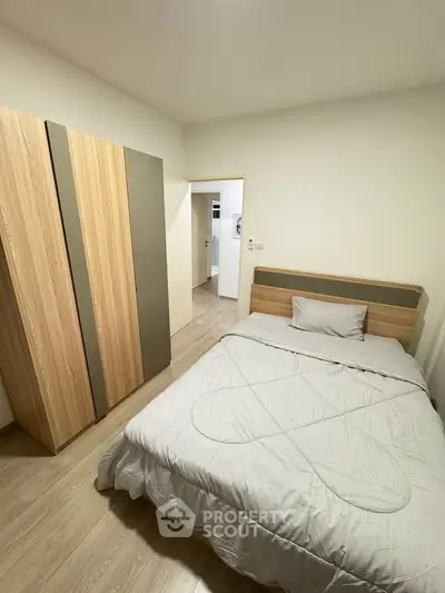 Cozy bedroom with modern wooden wardrobe and comfortable bed