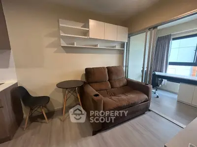 Modern living room with cozy brown sofa and stylish shelving in a compact apartment setting.