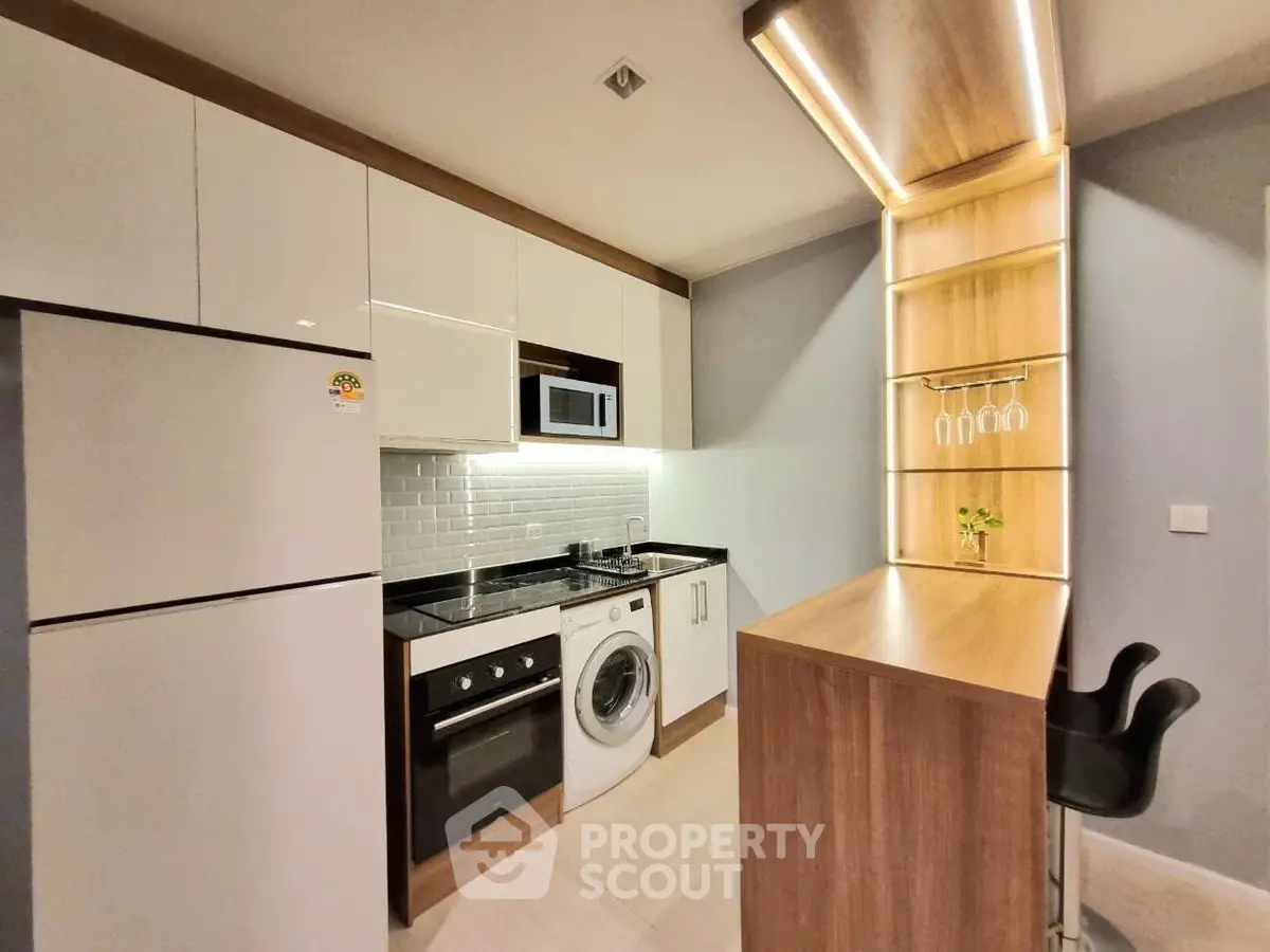 Modern kitchen with sleek appliances and stylish breakfast bar in contemporary apartment.