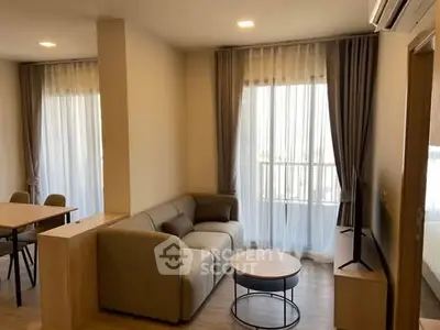 Modern living room with cozy sofa and large windows in stylish apartment.