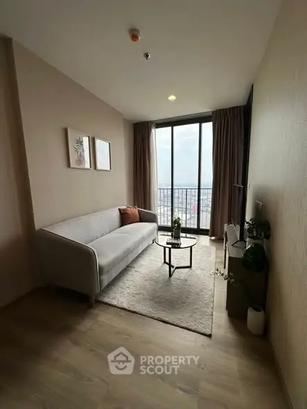 Modern living room with cozy sofa and city view from large window.