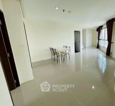 Spacious modern living area with glossy tiled floors and natural light.