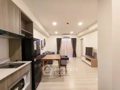 Modern open-plan living room with dining area and sleek kitchen appliances.