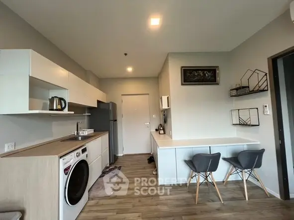 Modern kitchen with sleek design, featuring washing machine and dining area, perfect for urban living.