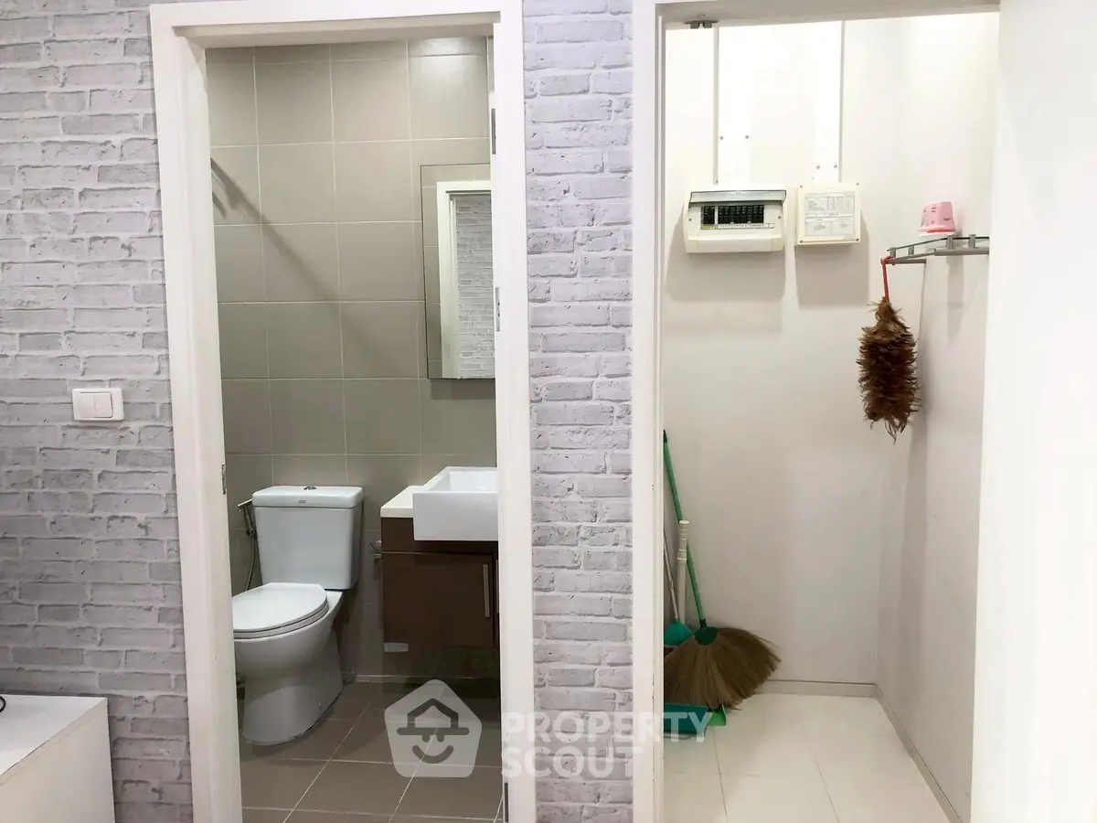 Compact bathroom with adjacent utility storage area in modern apartment.