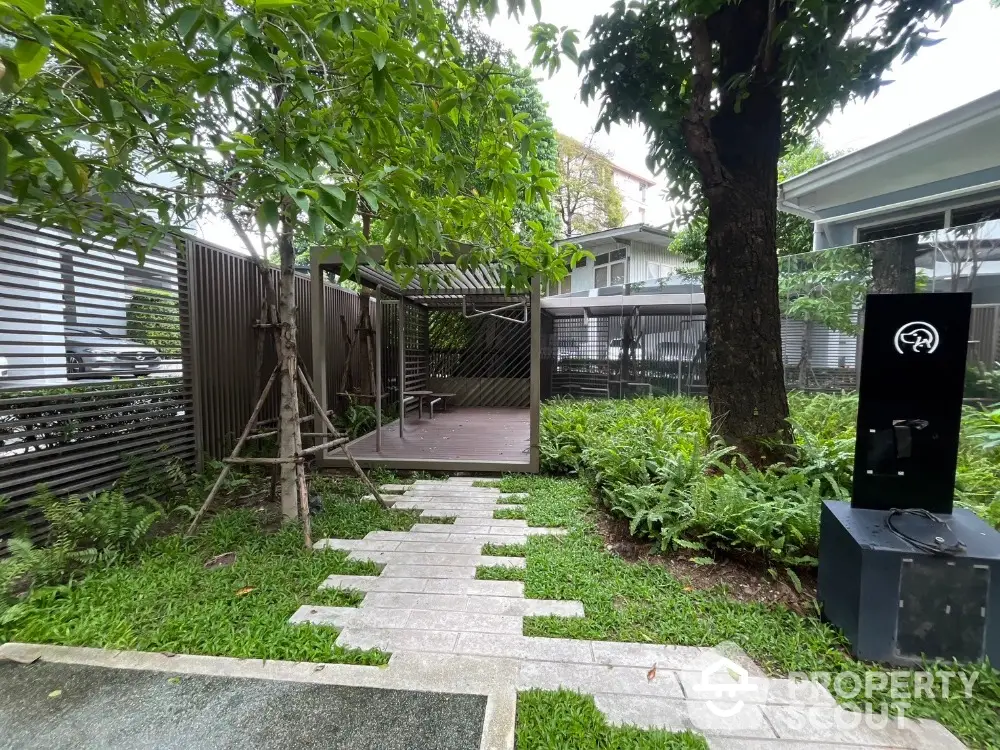 Charming garden area with lush greenery and modern outdoor seating, perfect for relaxation and leisure.