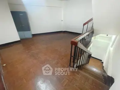 Spacious interior with wooden flooring and staircase, ideal for customization.