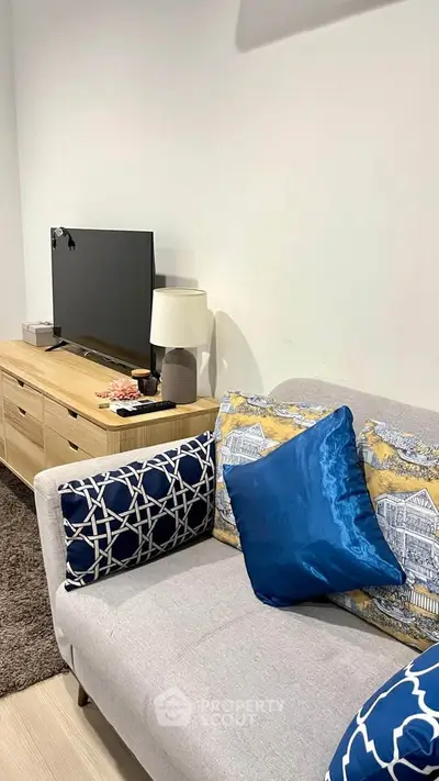 Cozy living room with modern decor, featuring a stylish sofa and entertainment unit.