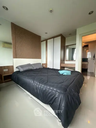 Modern bedroom with sleek design and cozy bedding in a stylish apartment.