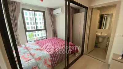 Cozy bedroom with ensuite bathroom and large window view in modern apartment