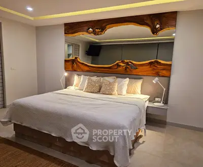 Luxurious bedroom with king-size bed and artistic wooden headboard, perfect for relaxation.