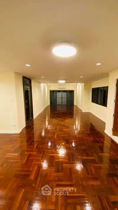 Spacious polished hardwood floor living room with modern lighting