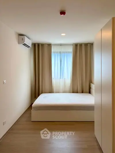 Modern minimalist bedroom with natural light and air conditioning
