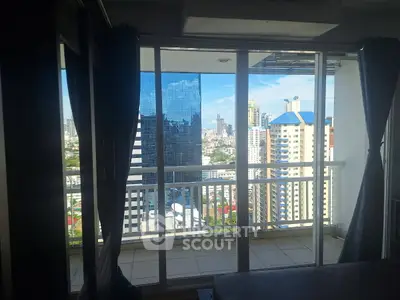 Stunning city view from high-rise apartment balcony with glass doors.