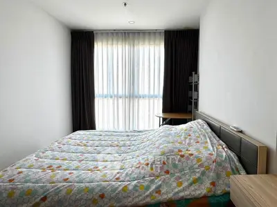 Cozy bedroom with large window and modern furnishings, perfect for relaxation and comfort.