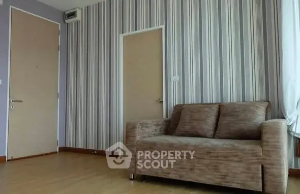 Modern living room with stylish striped wallpaper and cozy sofa