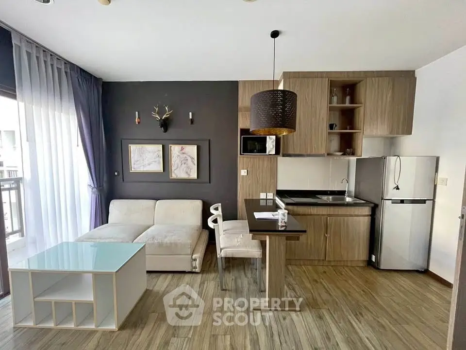 Modern living room with open kitchen, stylish decor, and natural light.